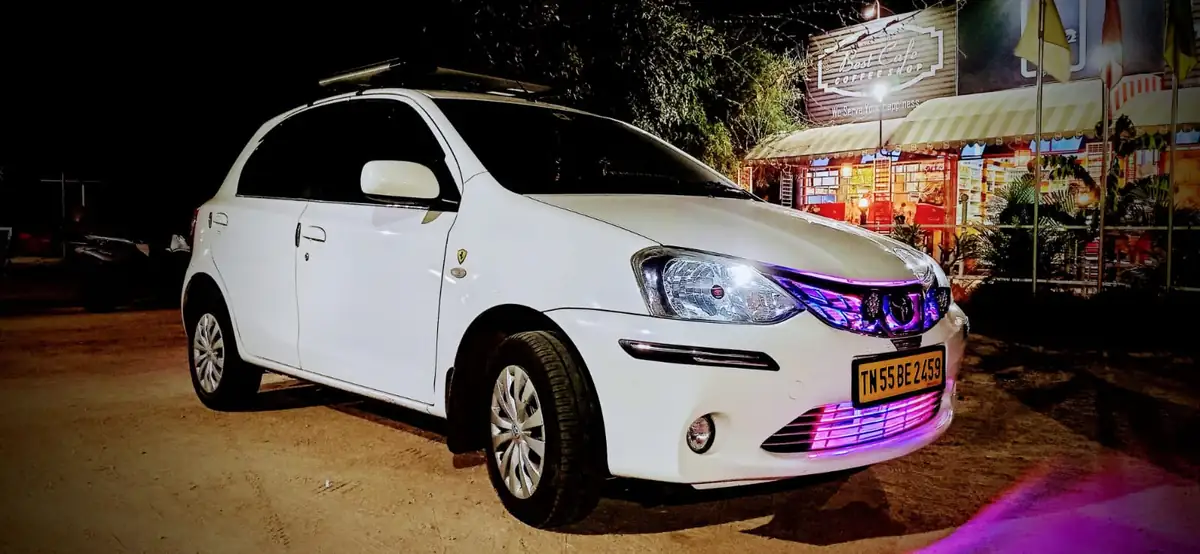 White premium MUV from JP Travel Hub photographed during an evening booking